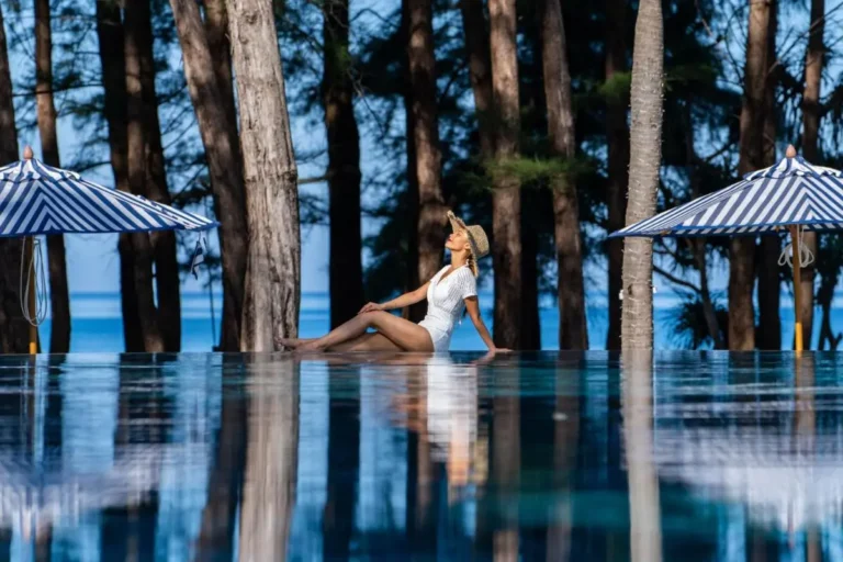 Serene Infinity Pool at Mai Khao Beach with Blue and White Umbrellas