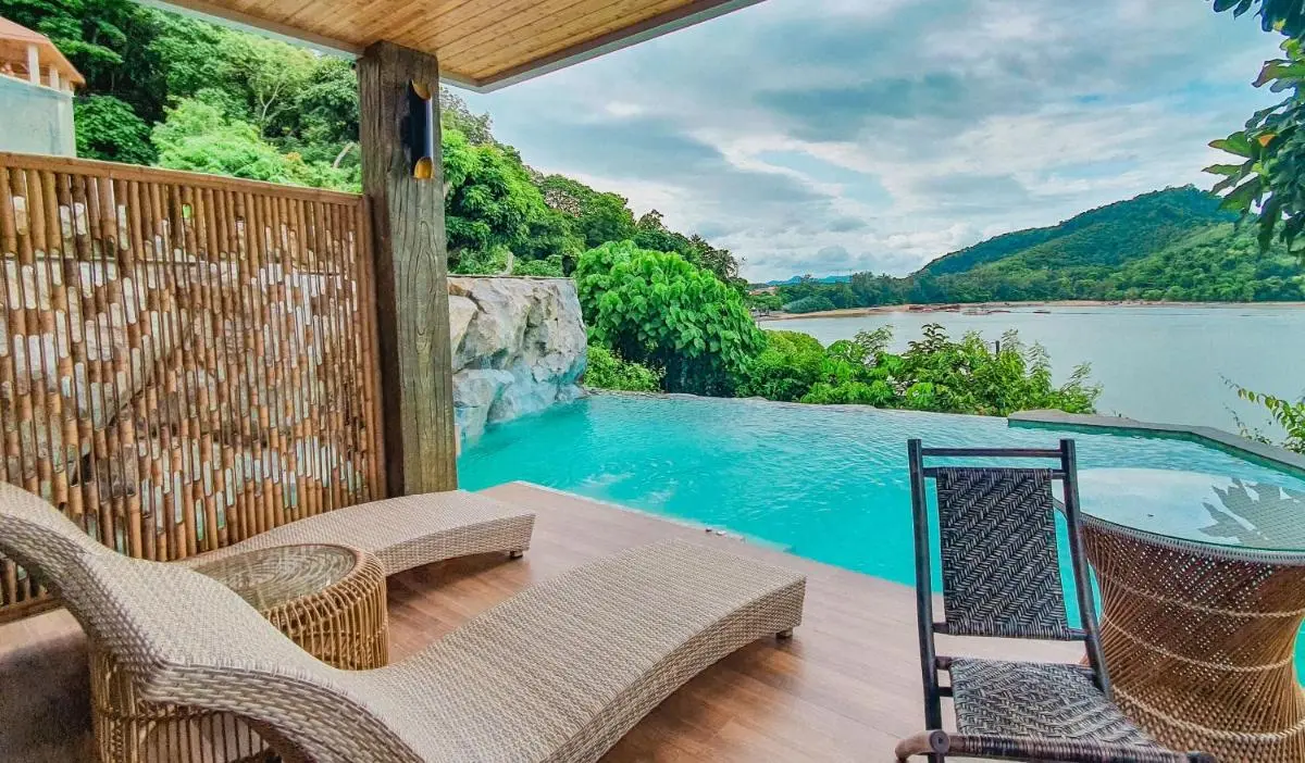 Serene Outdoor Infinity Pool Overlooking Water and Green Hills in Phuket Town