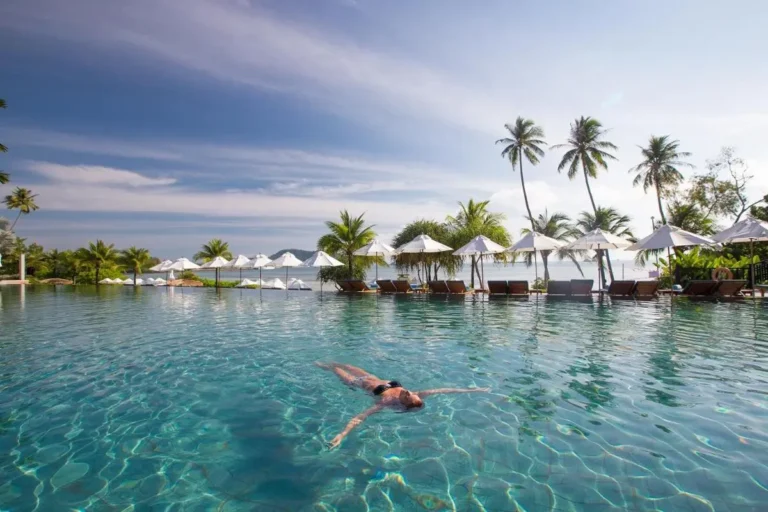 Serene Outdoor Infinity Pool with Lounge Chairs and Tropical Surroundings at Panwa Beach