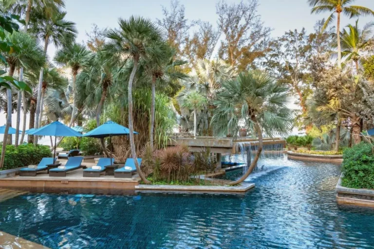 Serene Outdoor Pool Area with Waterfall and Tropical Surroundings at Mai Khao Beach