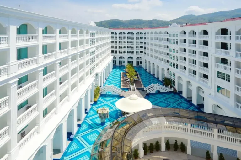 Spacious Enclosed Courtyard with Patterned Blue Flooring and Palm Trees at Patong Beach