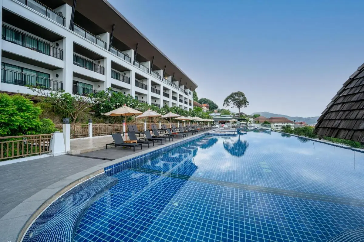Spacious Outdoor Swimming Pool and Jacuzzi Area with Lounge Chairs and Modern Architecture at Patong Beach