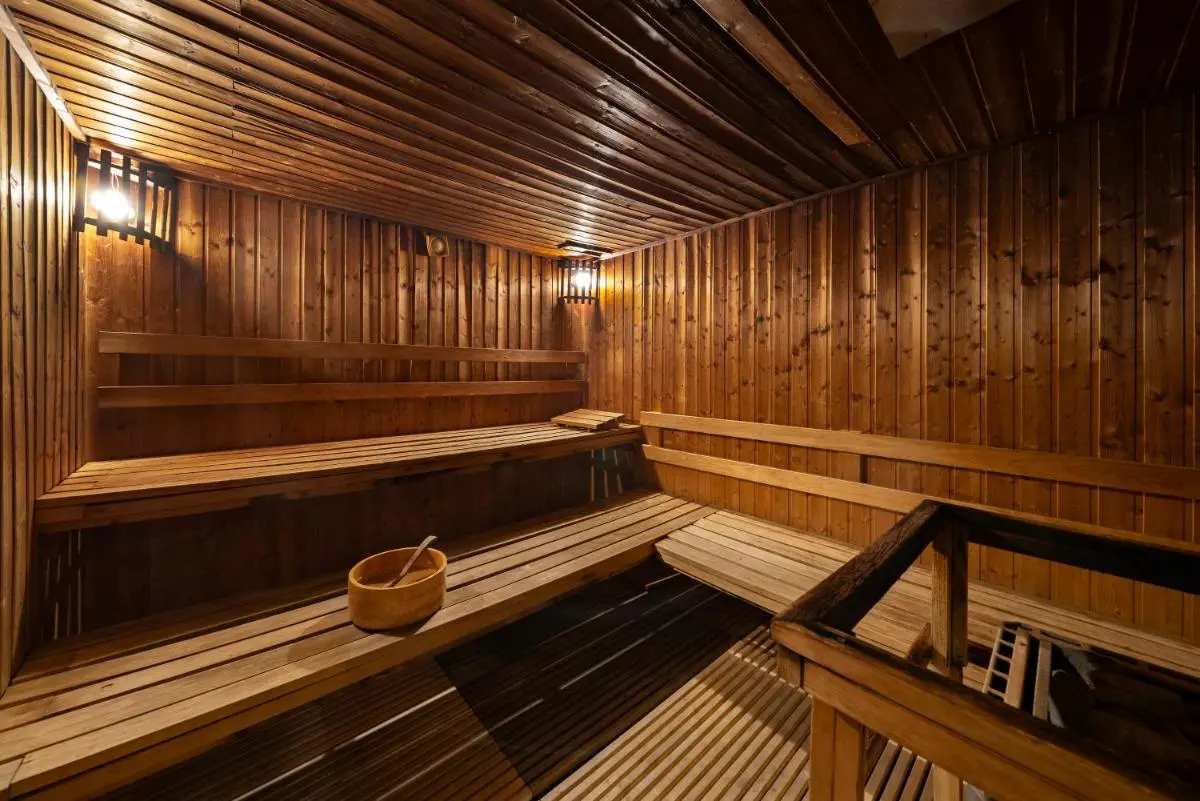Traditional Wooden Sauna Room with Benches and Heated Stones in Pathumwan Interior