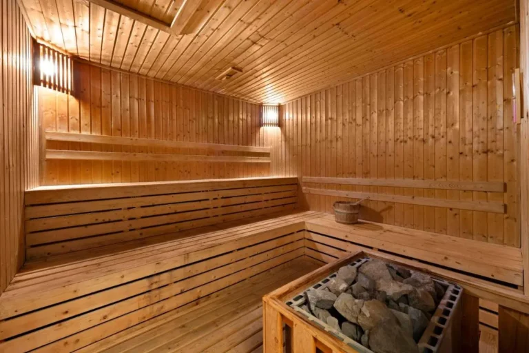 Traditional Wooden Sauna Room with Tiered Benches and Heater in Wattana