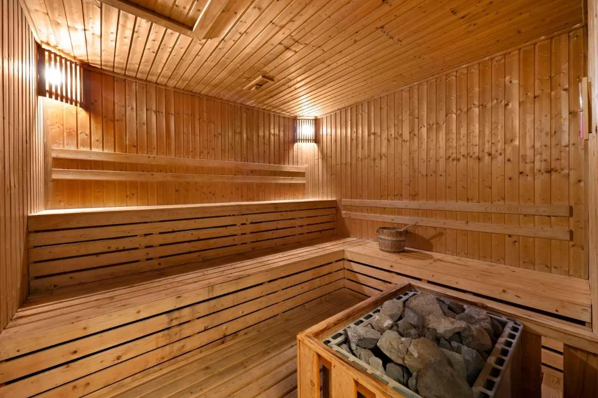 Traditional Wooden Sauna Room with Tiered Benches and Heater in Wattana