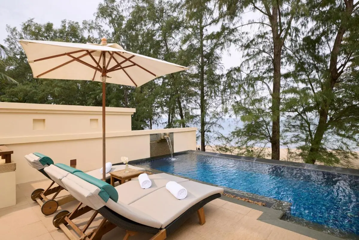 Tranquil Outdoor Infinity Pool Area with Lounge Chairs Overlooking Bang Tao Beach