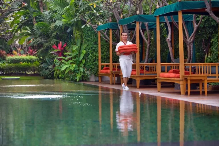 Tranquil Outdoor Pool and Relaxation Area Surrounded by Lush Greenery in Bang Rak