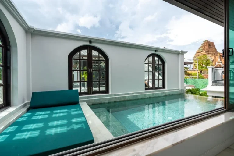 Tranquil Outdoor Pool Area with Arched Windows and Historic Views in Phra Sing Chiang Mai