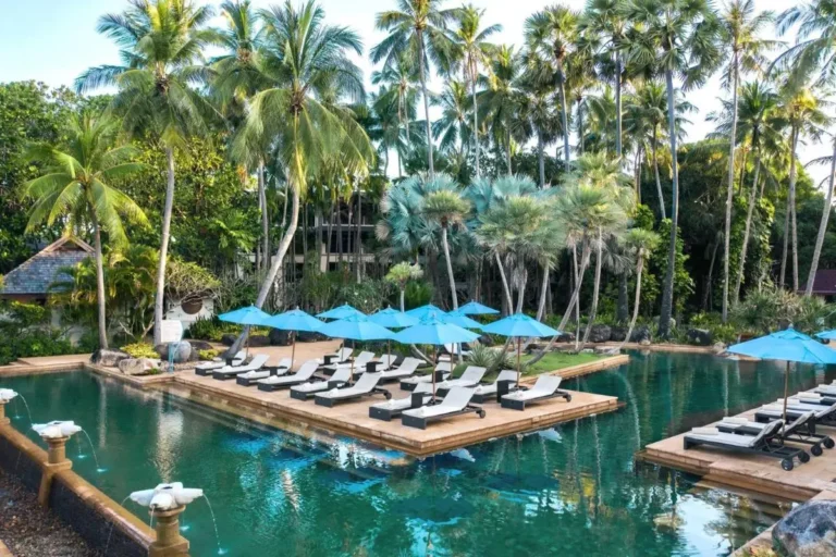 Tranquil Outdoor Pool Area with Cushioned Loungers and Tropical Surroundings at Mai Khao Beach