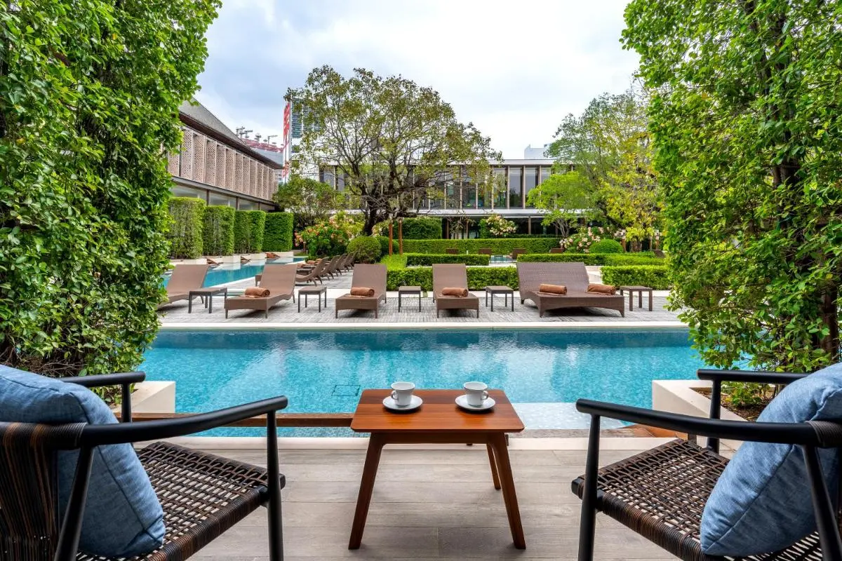 Tranquil Outdoor Pool Area with Lounge Chairs and Seating in Sathorn Courtyard