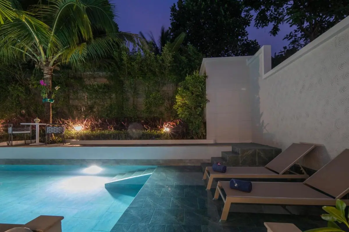 Tranquil Outdoor Pool Area with Lounge Seating and Garden in Phuket Town