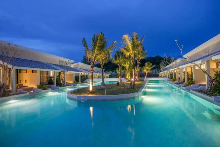 Tranquil Outdoor Pool Area with Palm-Lit Island and Modern Villas in Phuket Town