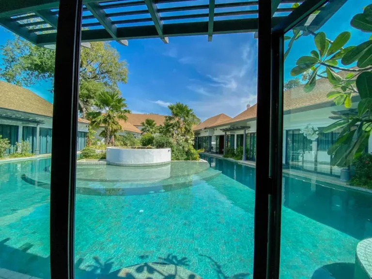 Tranquil Outdoor Pool Area with Palm Trees and Tiled Walkway in Chalong
