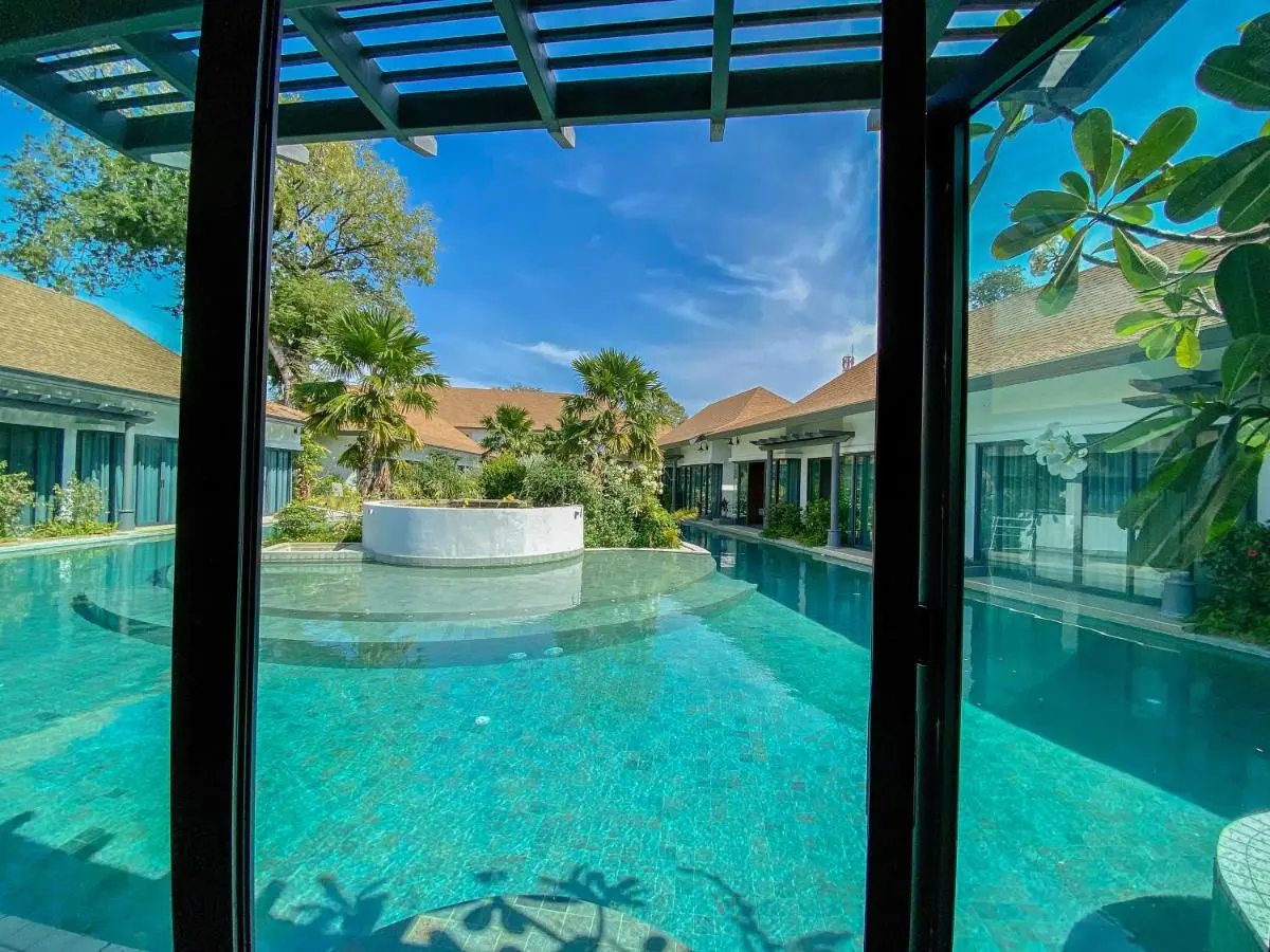 Tajh Pool Villas Tranquil Outdoor Pool Area with Palm Trees and Tiled Walkway in Chalong Phuket Province
