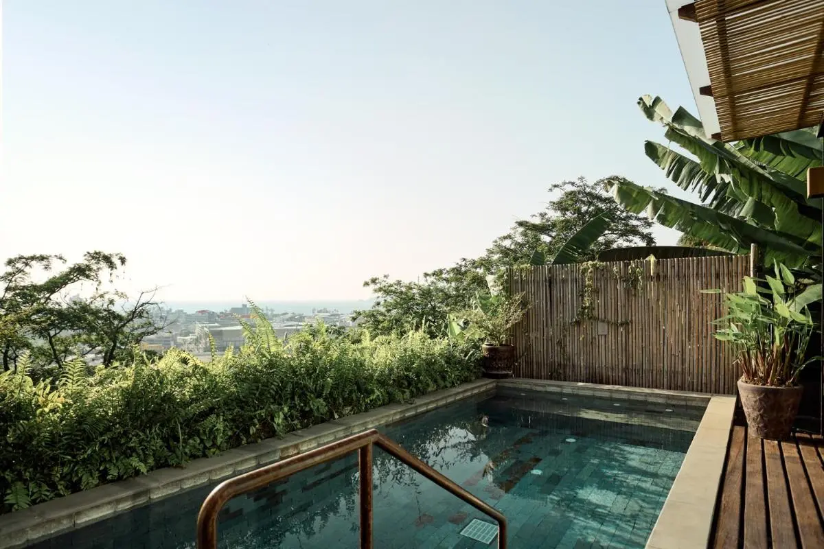 Tranquil Outdoor Pool Area with Wooden Deck and Lush Greenery Near Patong Beach