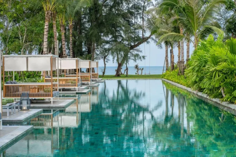 Tranquil Outdoor Swimming Pool with Cabanas and Ocean View at Mai Khao Beach