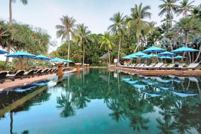 Tranquil Outdoor Swimming Pool with Lounge Chairs and Tropical Surroundings at Mai Khao Beach