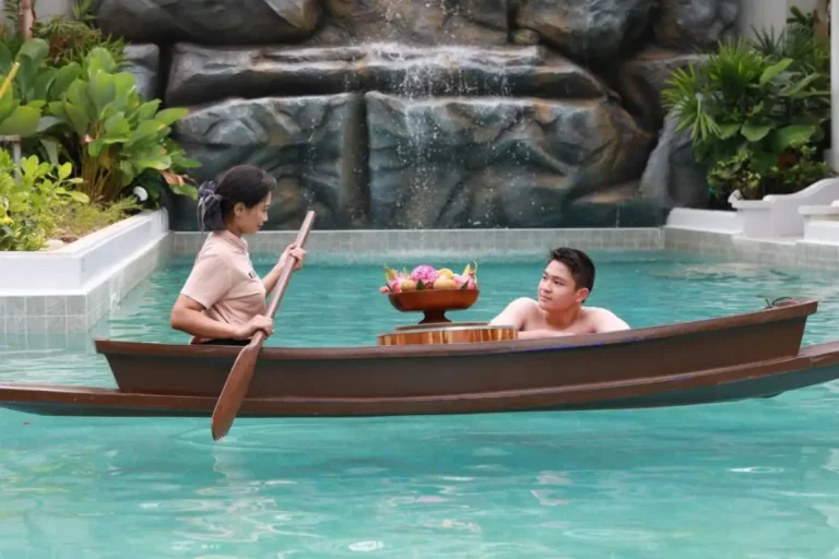 Tranquil Rectangular Swimming Pool with Waterfall and Floating Wooden Boat in Thalang