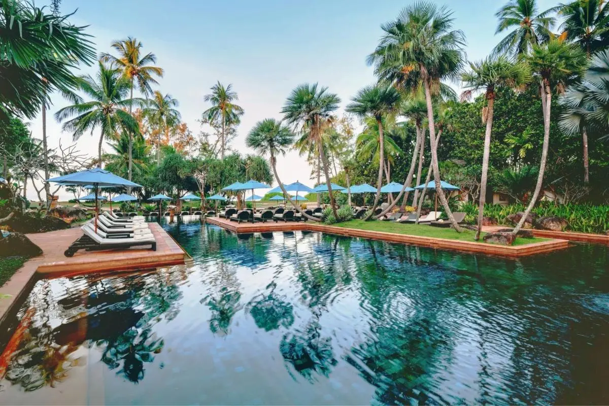 Tropical Outdoor Swimming Pool Area with Lounge Chairs and Ocean View at Mai Khao Beach
