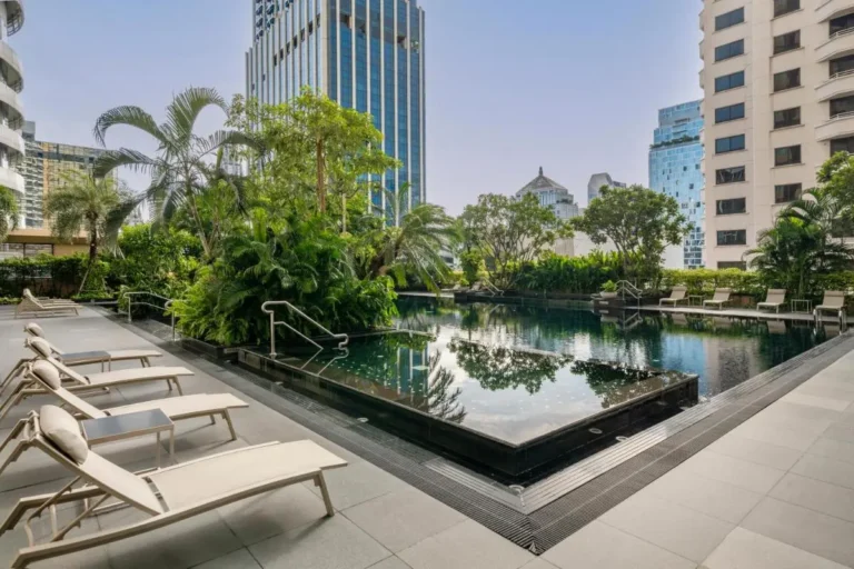 Urban Outdoor Pool Area with Lounge Seating and Tropical Plants in Pathumwan Bangkok