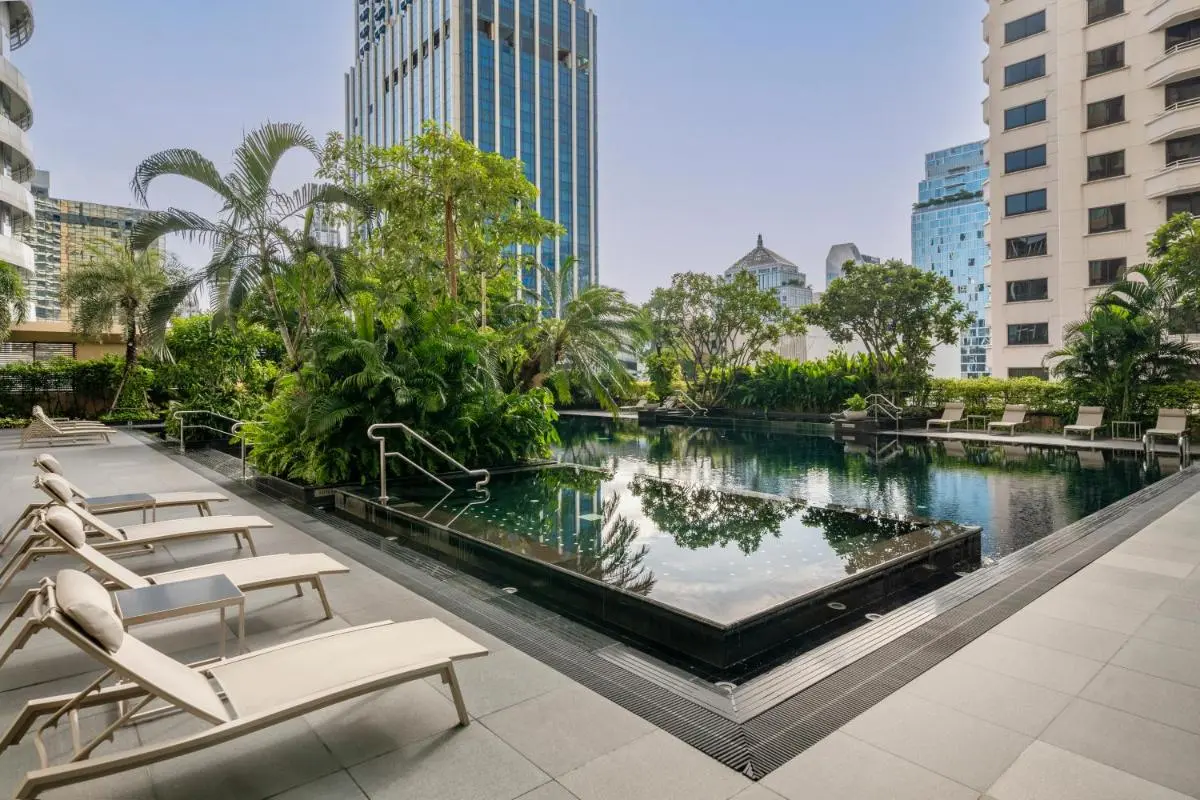 Urban Outdoor Pool Area with Lounge Seating and Tropical Plants in Pathumwan Bangkok