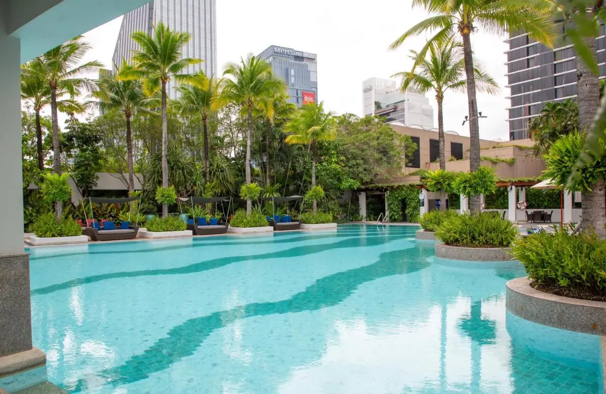 Urban Outdoor Swimming Pool Area with Lounge Seating and Tropical Greenery in Khlong Toei Bangkok