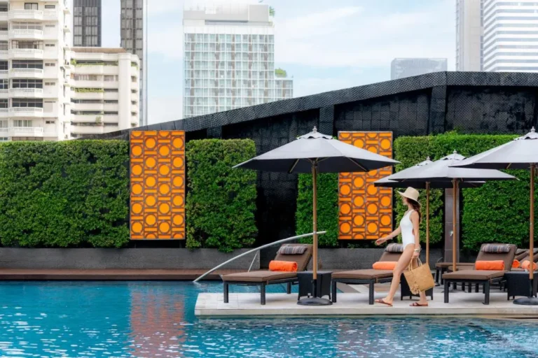 Urban Outdoor Swimming Pool with Lounge Chairs and Privacy Hedge in Wattana Bangkok