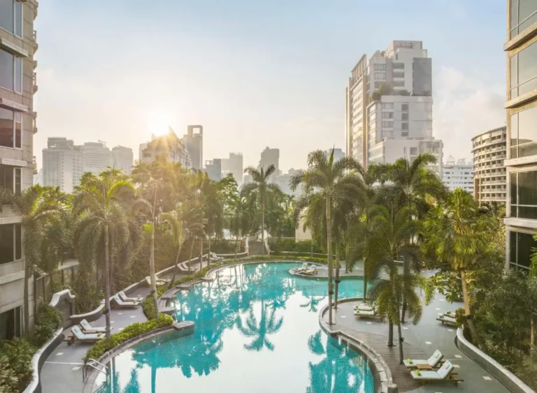 Urban Outdoor Swimming Pool with Palm Trees and Lounge Seating in Pathumwan Bangkok