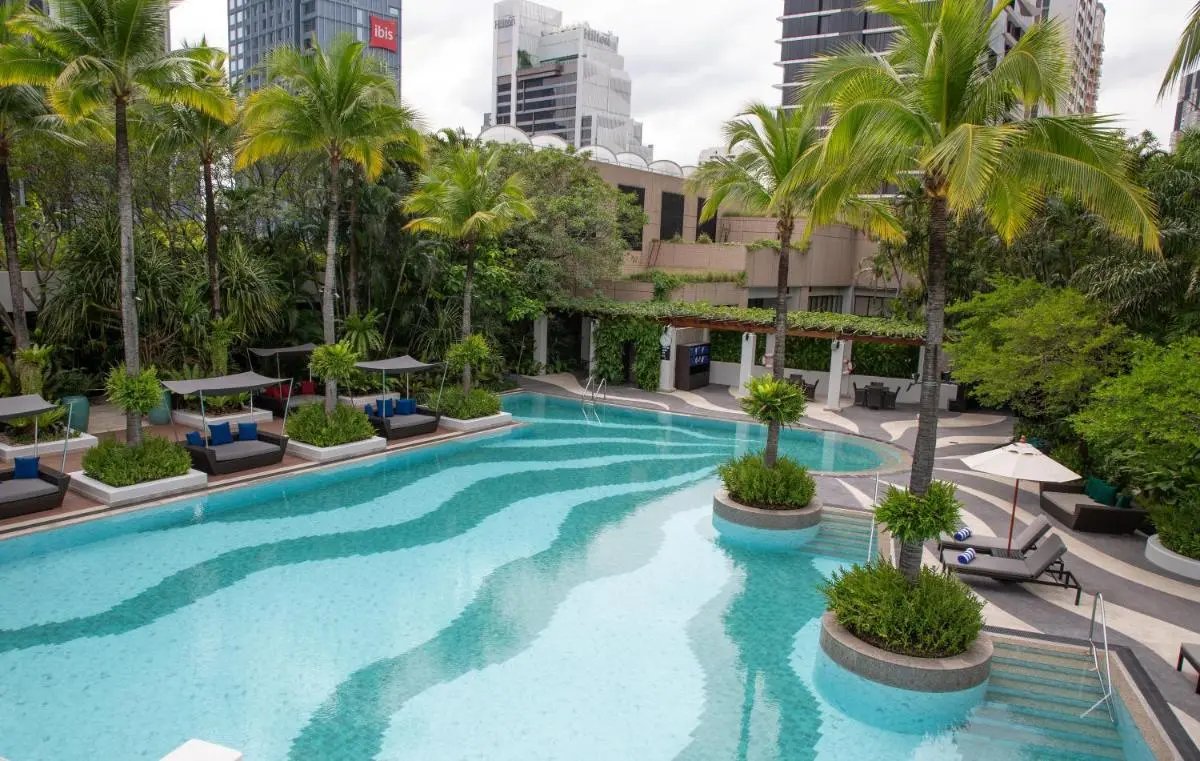 Urban Outdoor Swimming Pool with Tropical Landscaping and Relaxation Areas in Khlong Toei