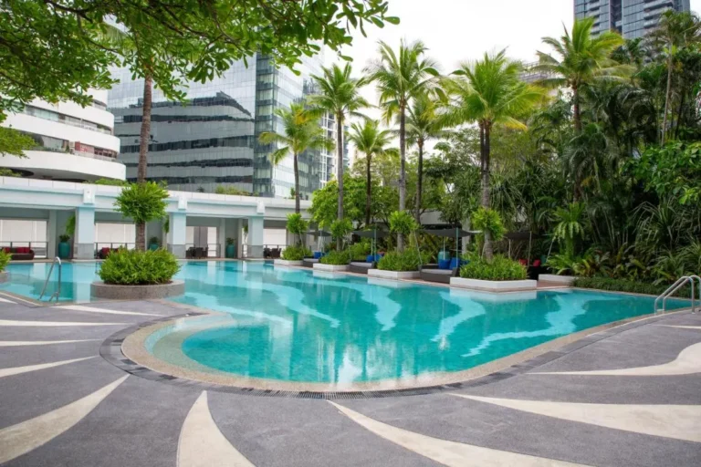 Urban Outdoor Swimming Pool with Tropical Landscaping and Shaded Lounge Areas in Khlong Toei Bangkok