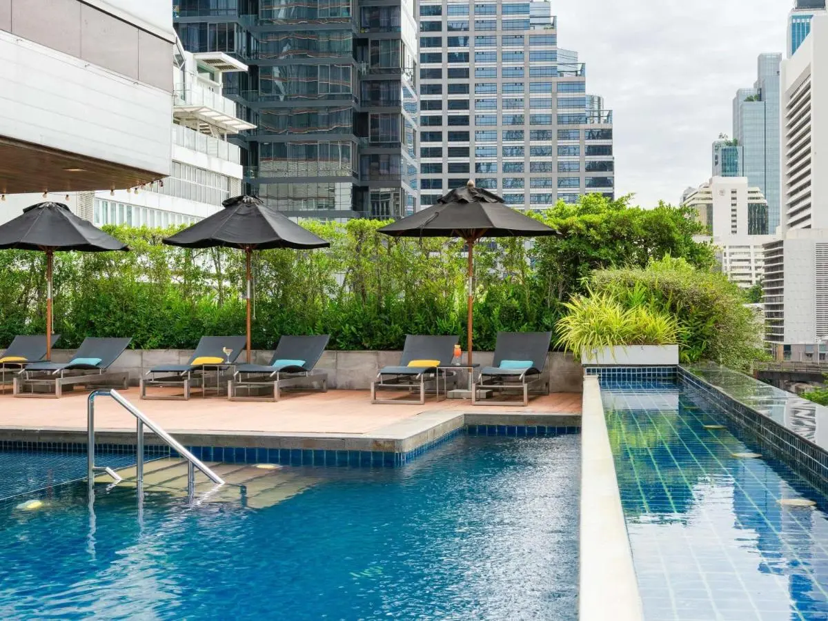 Urban Rooftop Pool Area with Lounge Chairs and City Views in Bang Rak