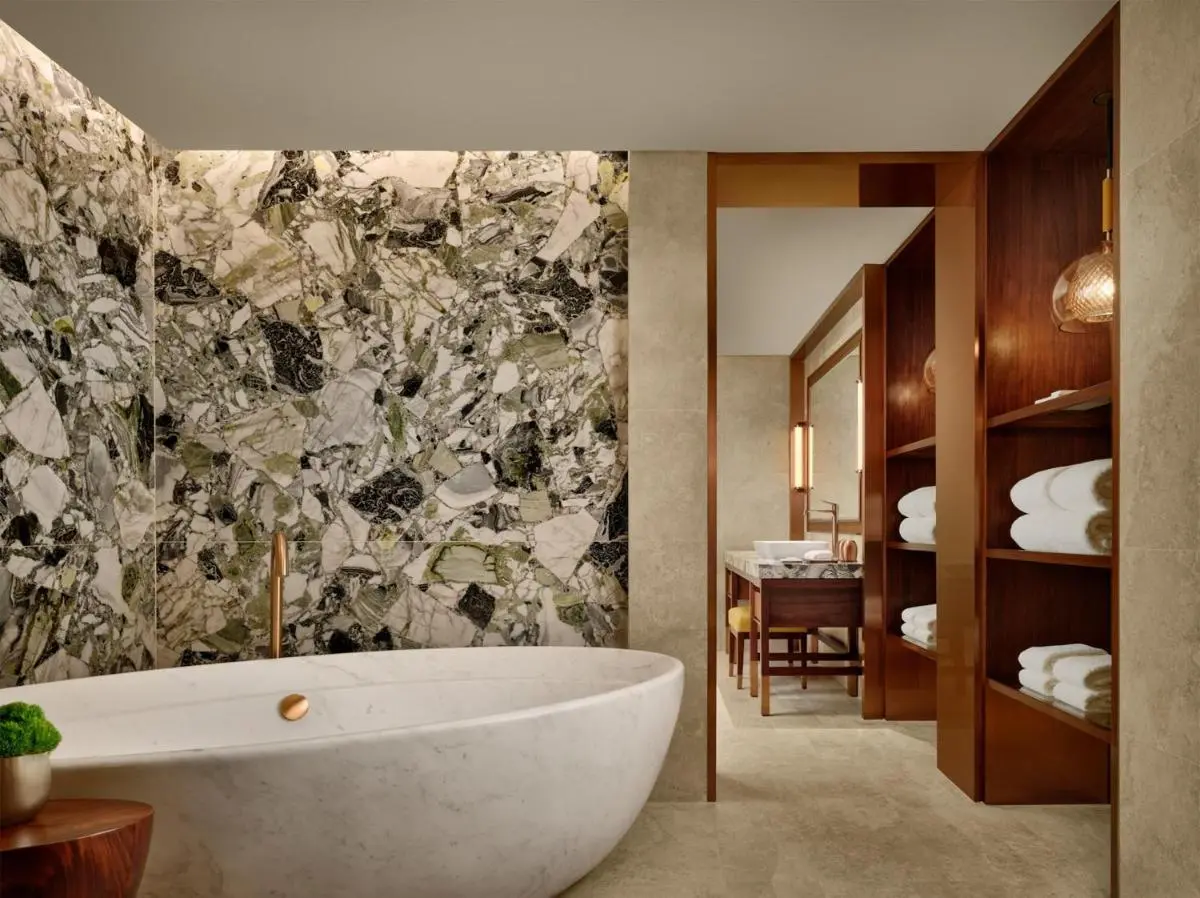White Marble Bathtub and Natural Stone Feature Wall Bathroom in Orchard